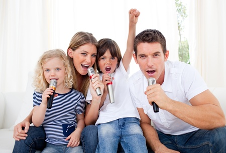 Portrait of a lively family singing through microphoneの写真素材