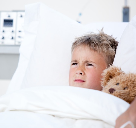 Sick little boy lying in a hospital bed の写真素材