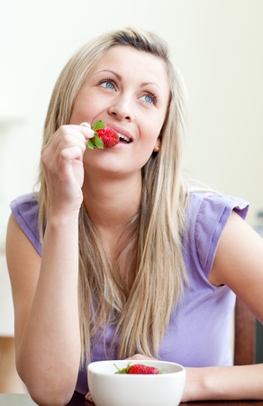 Portrait of a beautiful woman eating a strawberryの写真素材