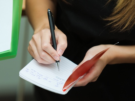 Blonde businesswoman writing on a notebook