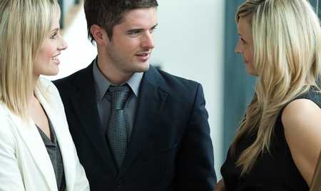 Businessman speaking with two blonde businessswomenの写真素材
