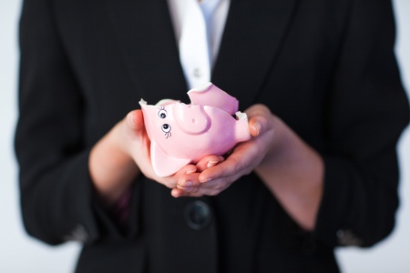 Business woman holding a broken piggy bankの写真素材