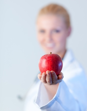 Doctor holding an apple with focus on the appleの写真素材