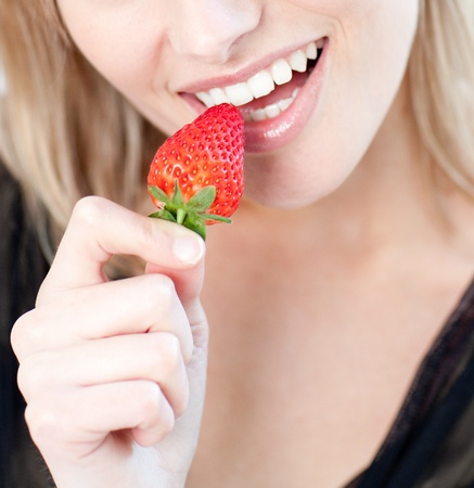 Caucasian woman eating a strawberry の写真素材