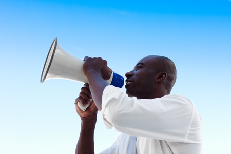 Angry African businessman shouting in a megaphoneの写真素材