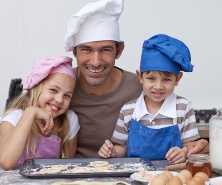 Happy father and children baking cookies togetherの写真素材