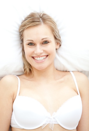 Smiling woman in underwear lying on bedの写真素材