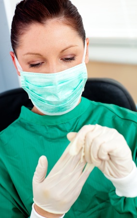 Beautiful female doctor with scrubs getting off her glovesの写真素材