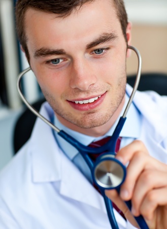 Charming young doctor examining with a stethoscope の写真素材