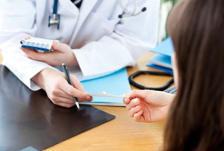 Portrait a charismatic male doctor giving note to a patienrの写真素材