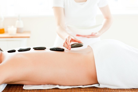 Close-up of a young man receiving hot stone on his back の写真素材