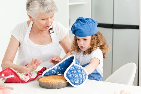 A little girl with her grandmother looking at the camera at homeの写真素材