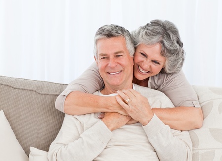 Mature woman hugging her husband at home