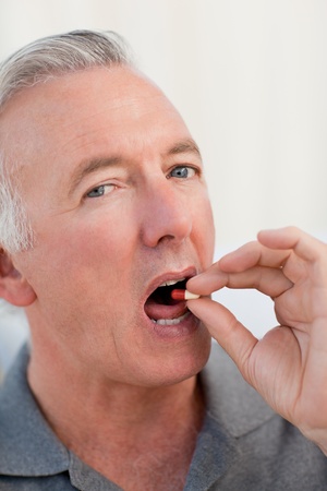 Retired man taking pillsの写真素材