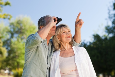 Couple looking at the sky with their binocularsの写真素材