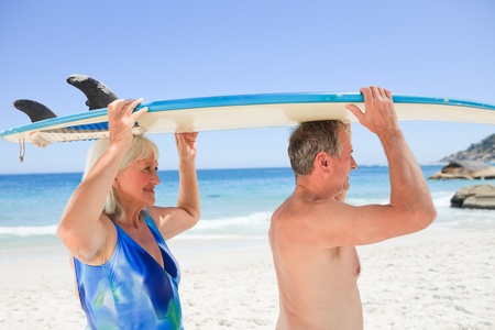 Senior couple with their surfboardの写真素材