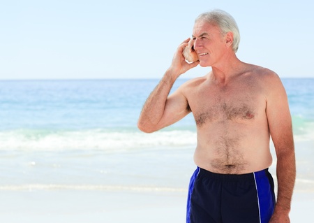 Senior man listening to his shellの写真素材