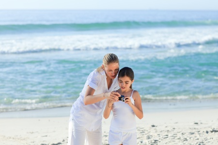 Little girl taking a photo of herself and her motherの写真素材