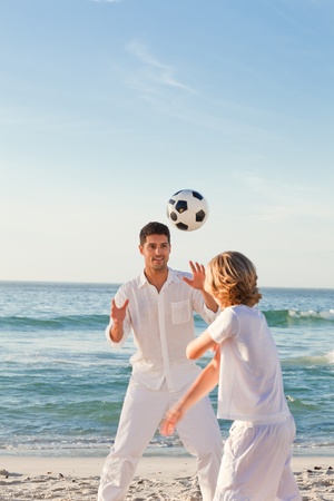 Father playing with his son on the beachの写真素材
