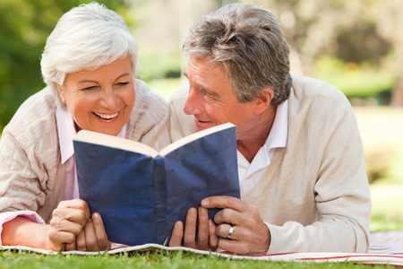 Couple reading a book in the parkの写真素材