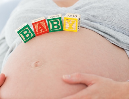 Close up of a pregnant woman with baby letters on her bellyの写真素材