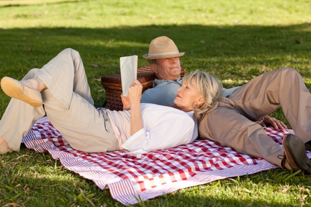 Woman reading while her husband is sleeping in the parkの写真素材