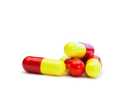 Yellow and red pills on a white backgroundの写真素材