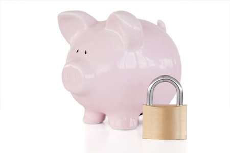 Pink piggy bank and padlock against a white background. の写真素材