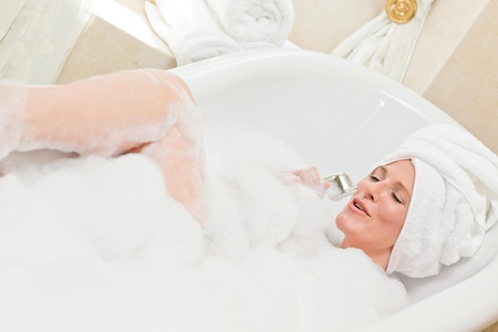 Charming woman taking a bath with a towel on her head の写真素材