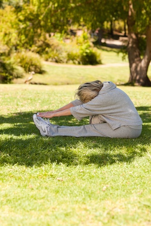 Mature woman doing her streches in the parkの写真素材