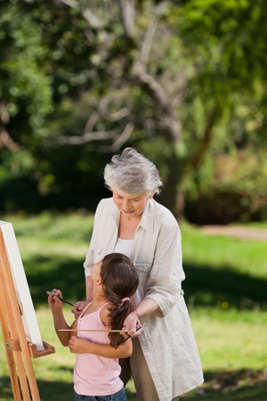 Grandmother and her granddaughter painting in the gardenの写真素材