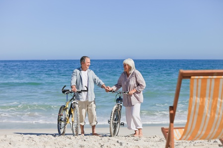 Elderly couple with their bikes on the beach Elderly couple with their bikes on the beach