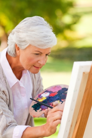 Mature woman painting in the parkの写真素材
