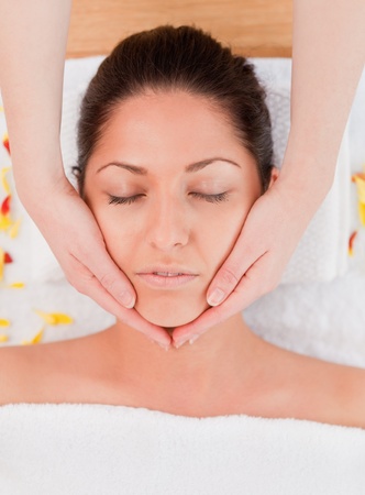 dark-haired woman having a facial massage eyes closedの写真素材