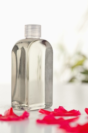 Glass flask an pink petals the camera focus on the flaskの写真素材