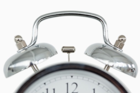 Close up of an old fashioned alarm clock against a white background