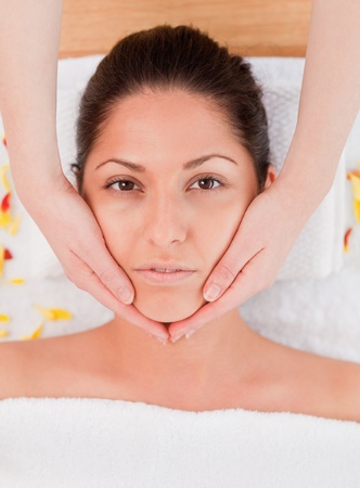 pretty woman having a facial massage looking at the cameraの写真素材
