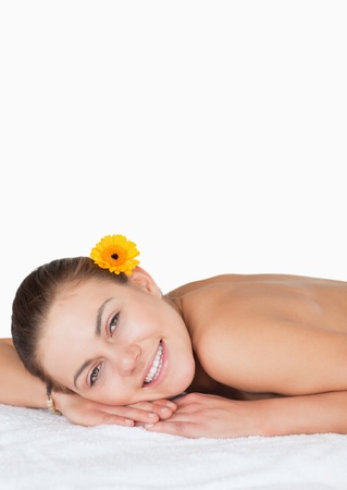 Portrait of a dark-haired woman with a flower on her ear in a spaの写真素材