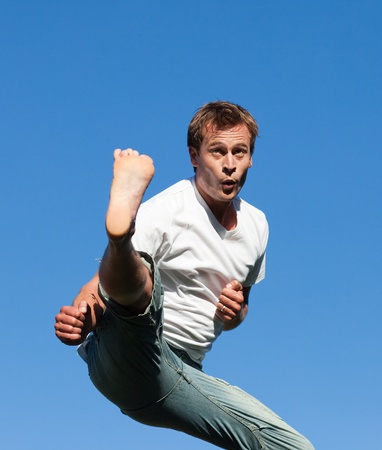 Smiling Man jumping in the air outdoorの写真素材