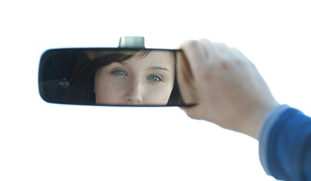 Brunette woman looking in the rear-view mirrorの写真素材