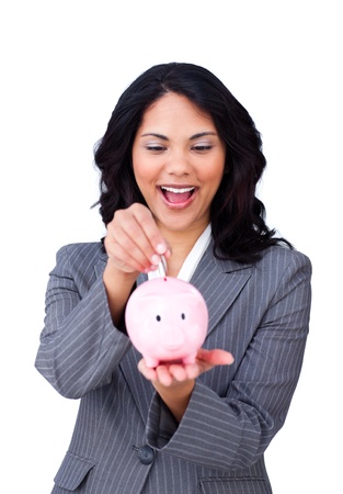Happy ethnic businesswoman saving money in a piggybank の写真素材
