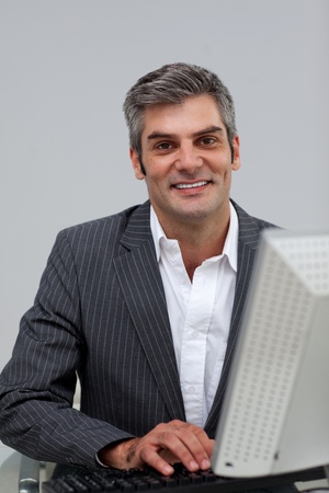 Self-assured male executive working at a computer の写真素材