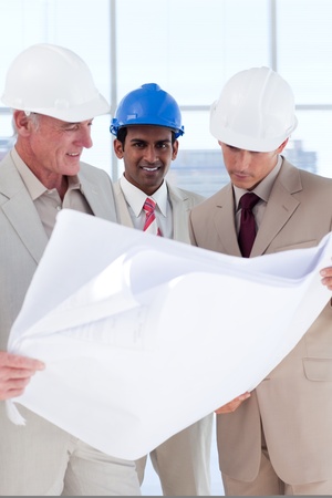 Three engineer co-workers studying plansの写真素材