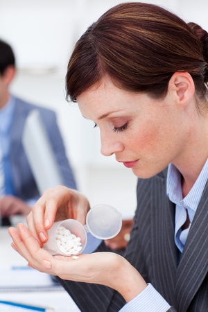 Portrait of a young businesswoman taking pillsの写真素材