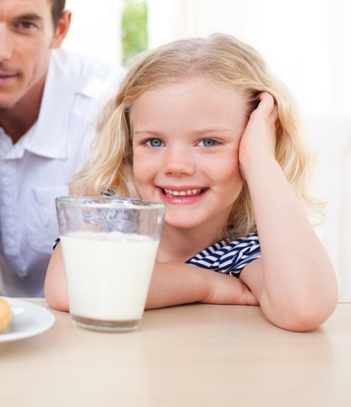 Smiling little girl drinking milkの写真素材