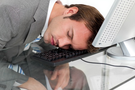 Close-ep of a tired businessman sleeping on his desk の写真素材