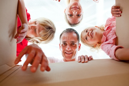 Cheerful family unpacking boxes の写真素材