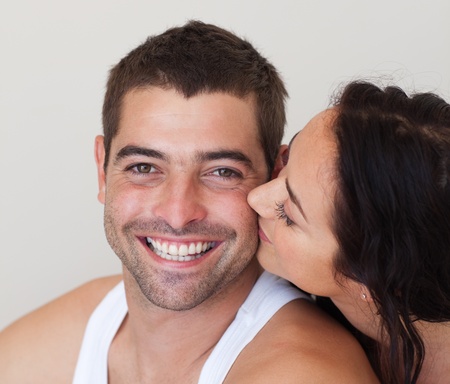 Radiant woman kissing her cheerful husbandの写真素材
