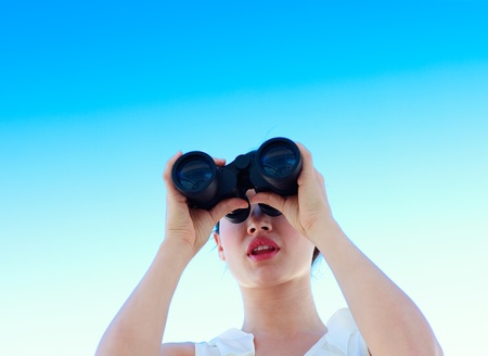 Cute  businesswoman looking through binocularsの写真素材