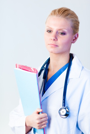Serious doctor holding a clipboardの写真素材